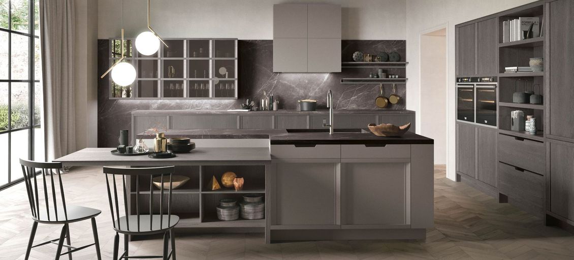 Una cucina con tavolo e sedie e una grande isola al centro.