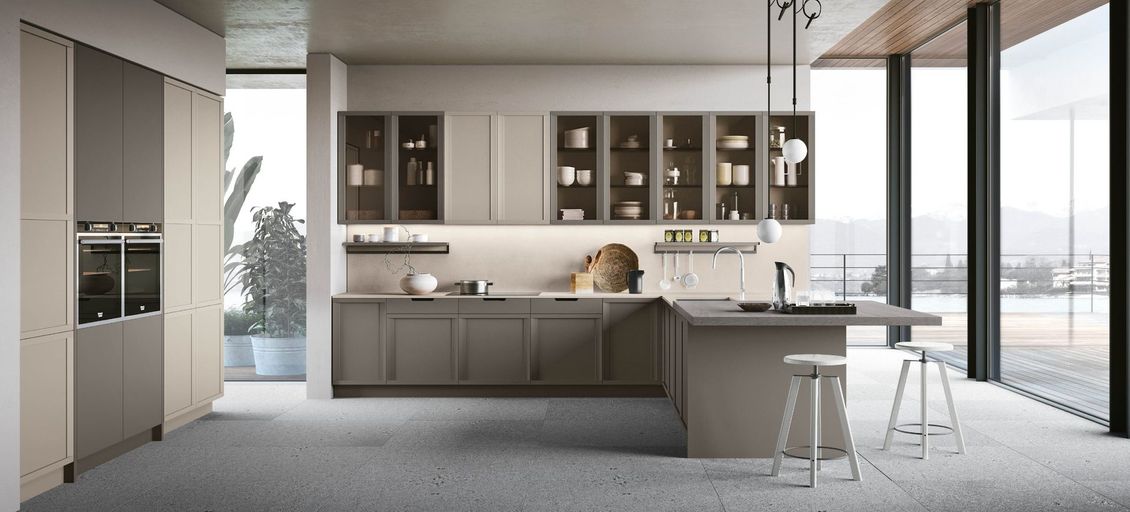 Una cucina con una grande isola al centro e molte finestre.