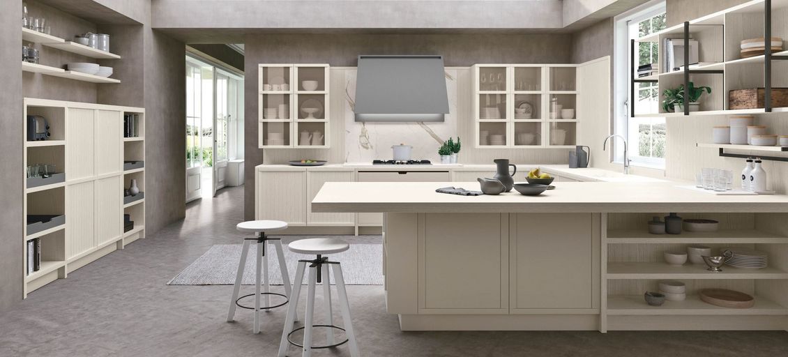 Una cucina con mobili bianchi e una grande isola al centro