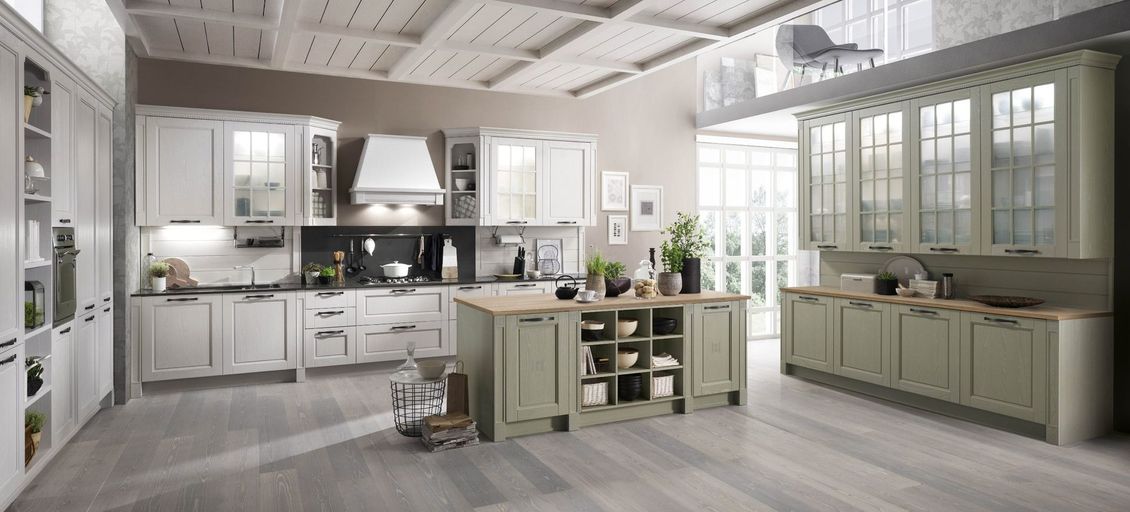 Una cucina con mobili bianchi e una grande isola al centro.