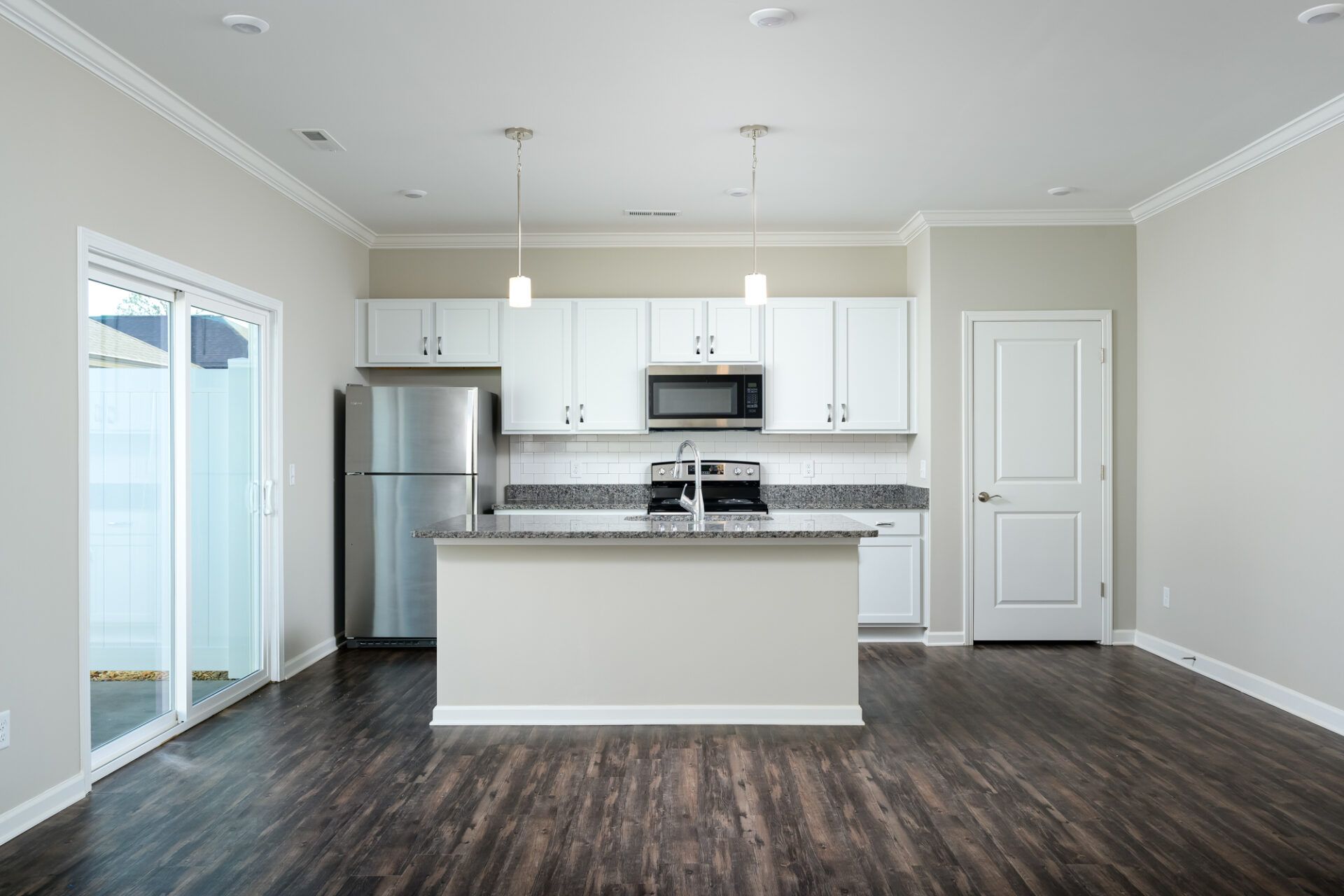 An empty kitchen with white cabinets and stainless steel appliances at Ashford Villas in Chattanooga, TN.