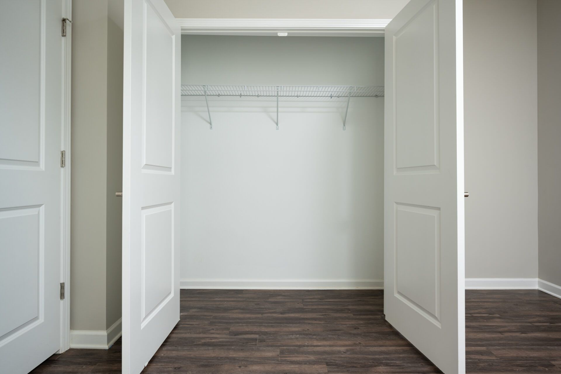 An empty closet with the doors open and a wooden floor at Ashford Villas in Chattanooga, TN.