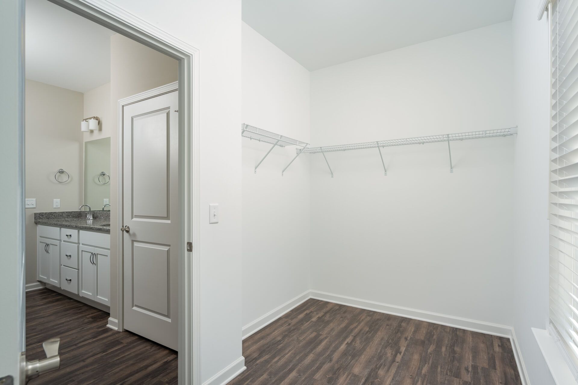 An empty room with hardwood floors and a bathroom in the background  at Ashford Villas in Chattanooga, TN.
