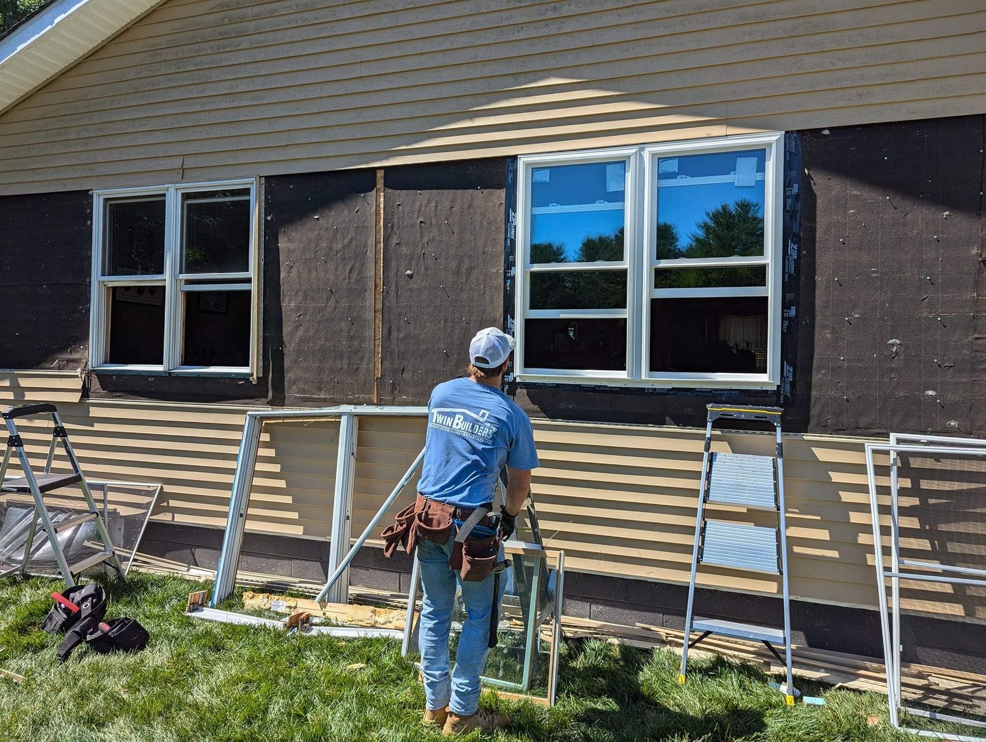 A man is working on the side of a house.