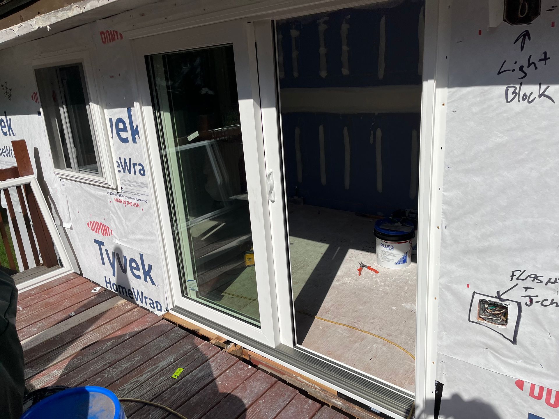 A sliding glass door is being installed on the side of a house.