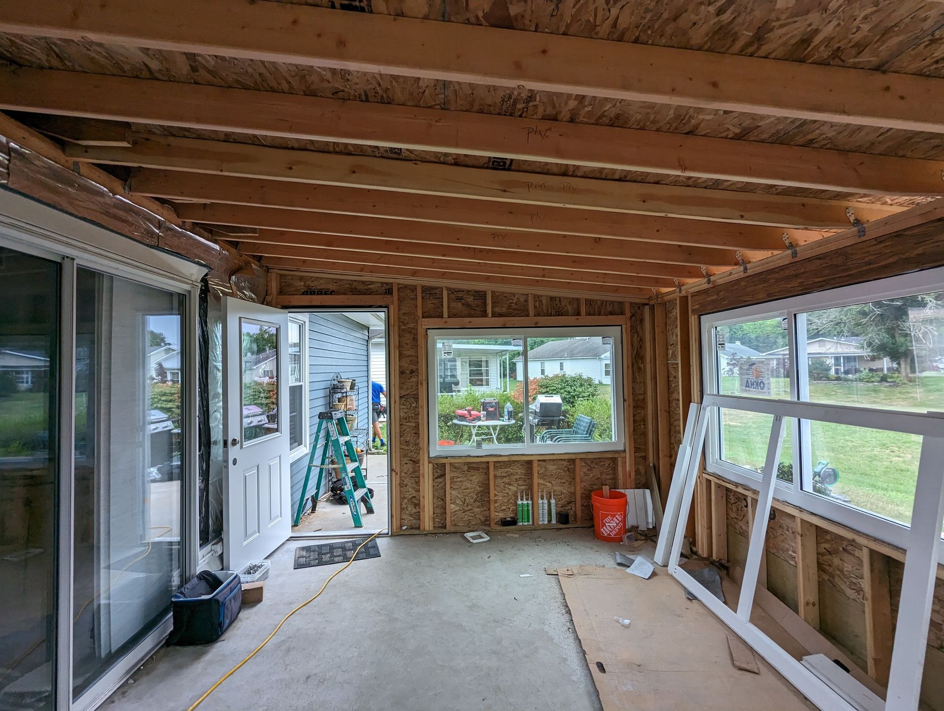 A room with a lot of windows and a ladder in it.