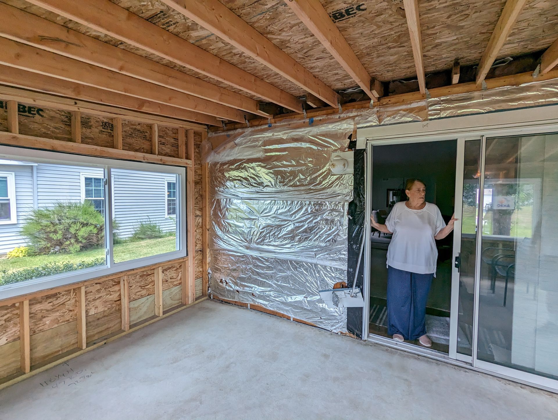 A woman is standing in a room with a sliding glass door.