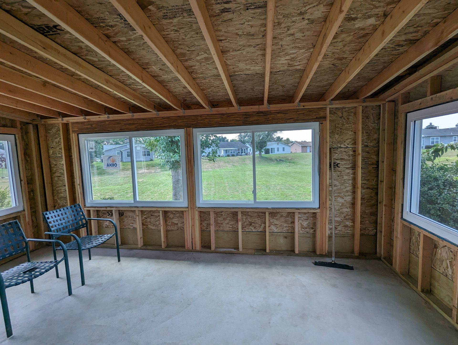 A room with a lot of windows and chairs in it.