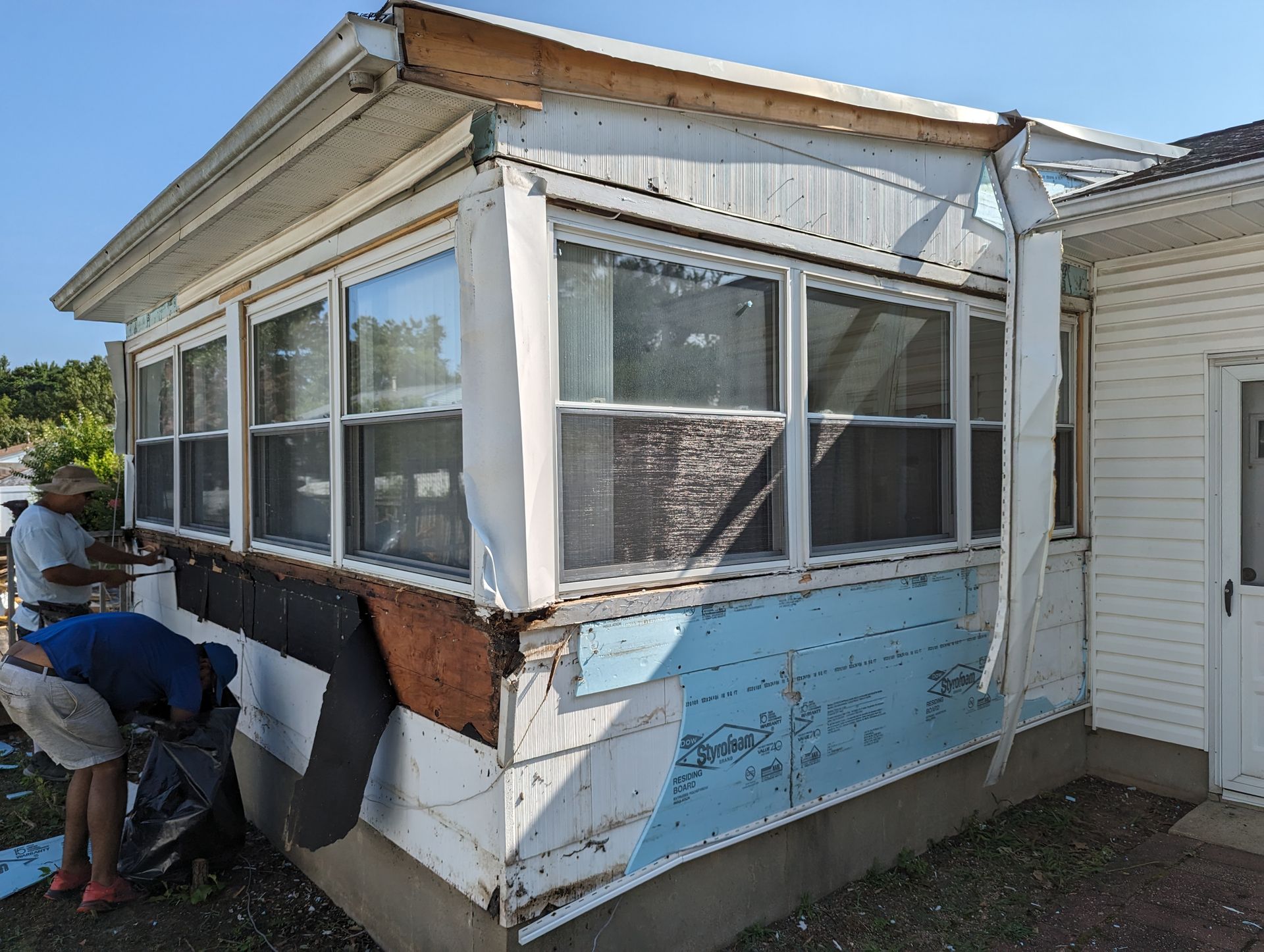 A man is working on the side of a house.