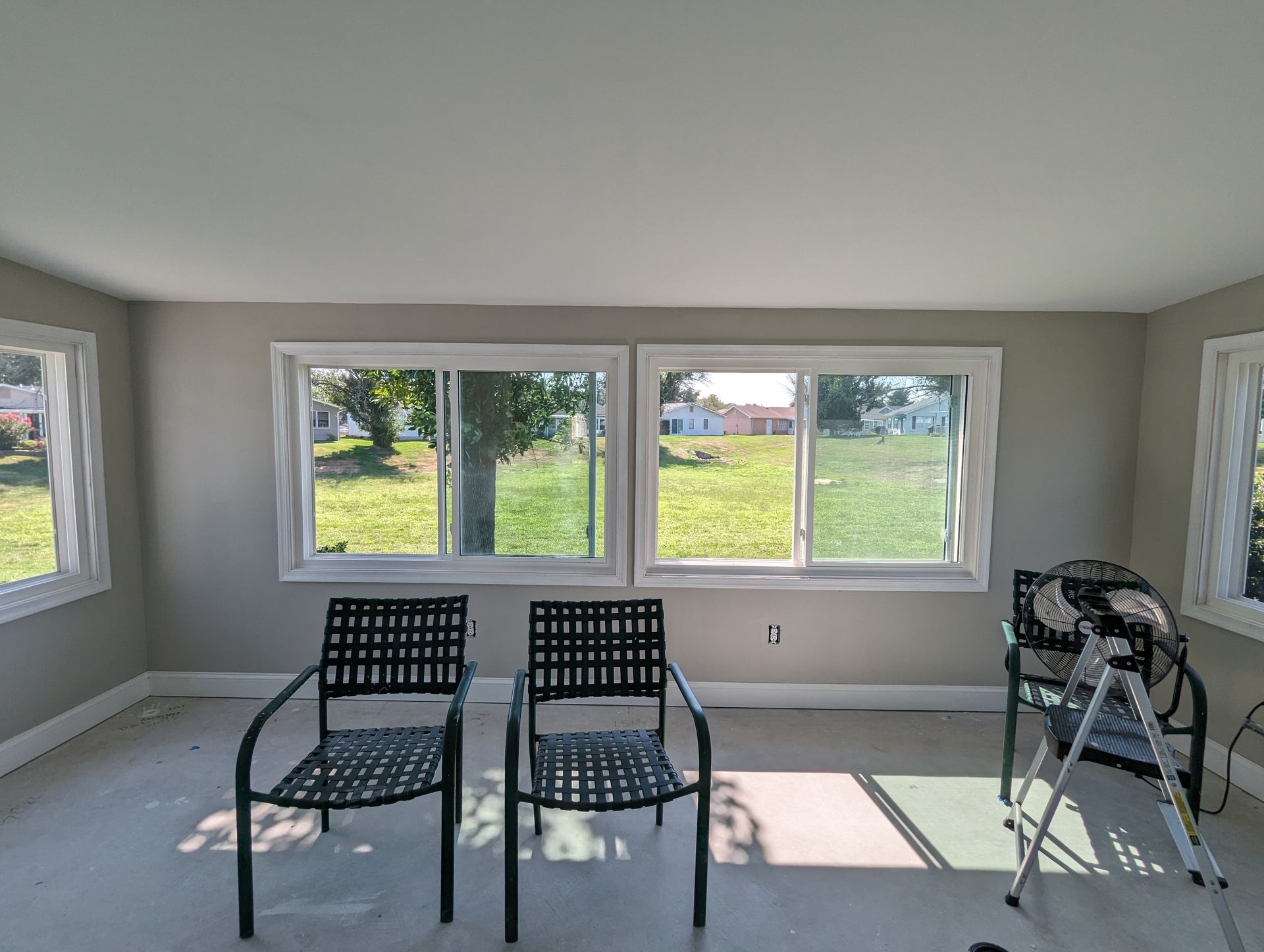 A room with two chairs and a ladder in it.