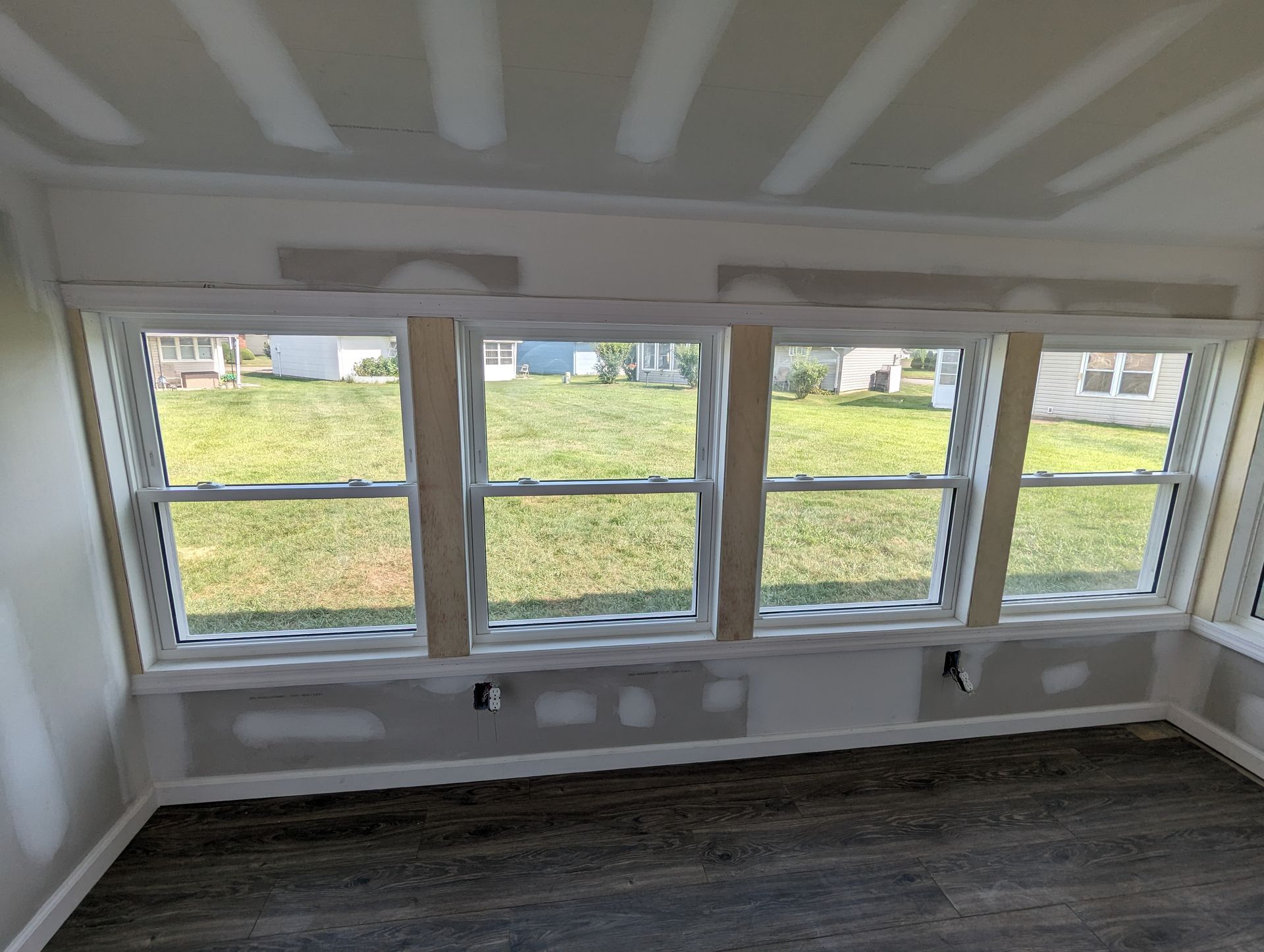 A room with a lot of windows and a view of a grassy field.