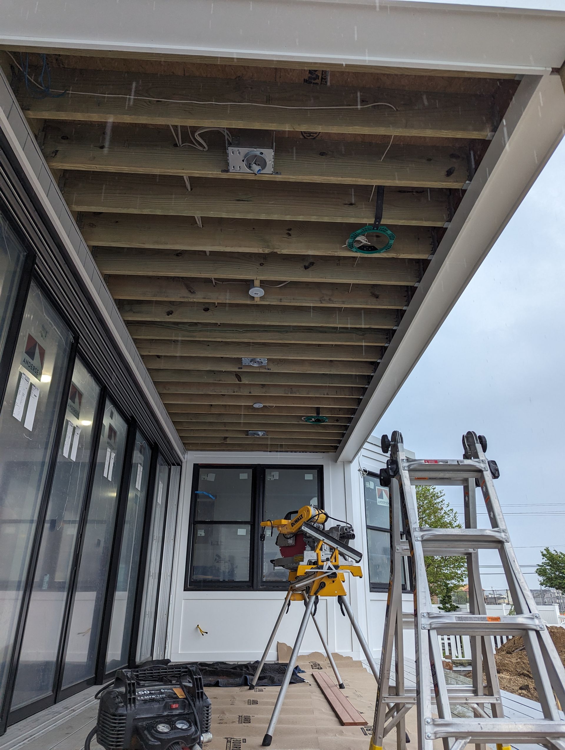 A wooden deck is being built on the side of a building.
