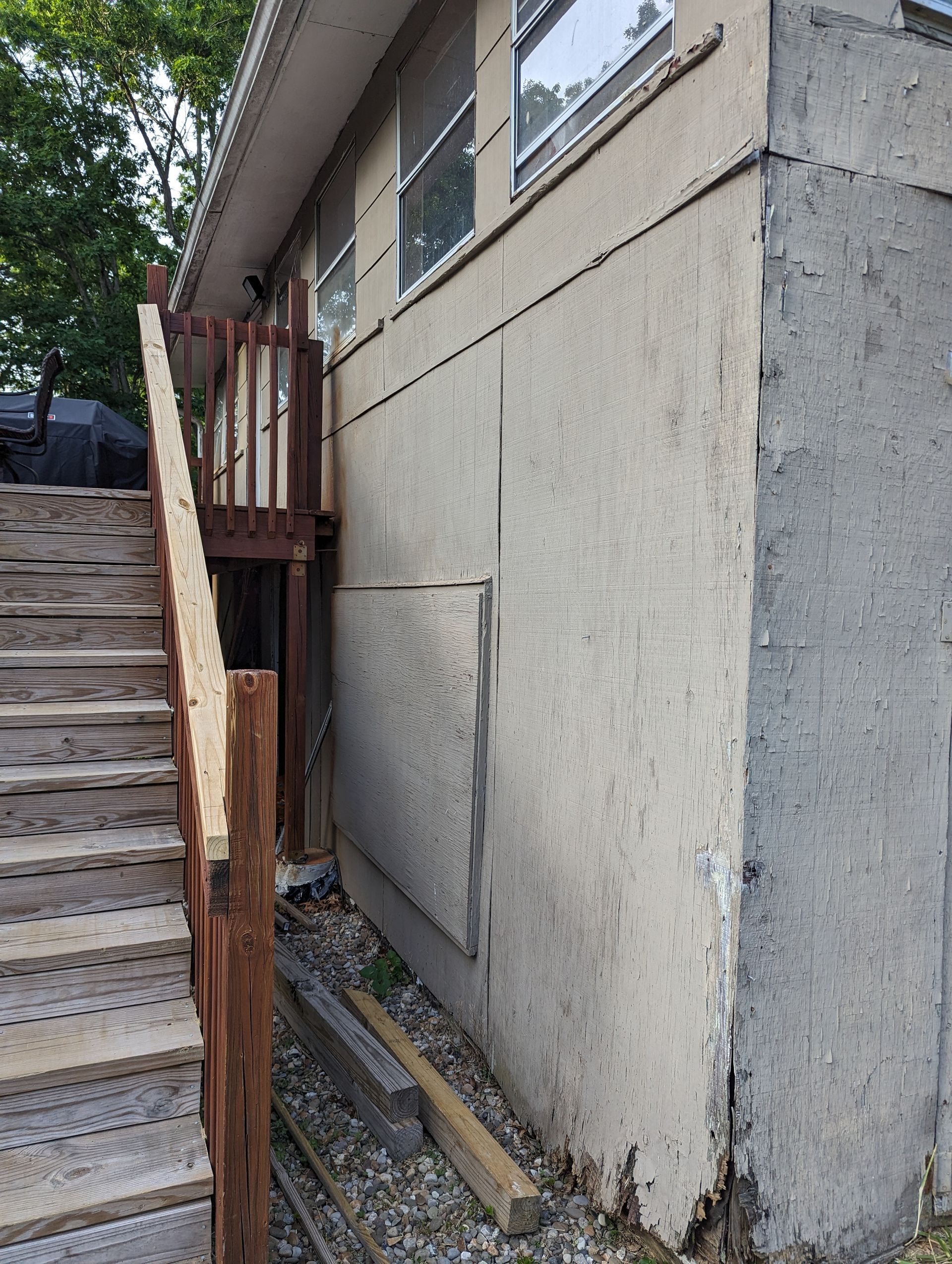 A house with stairs leading up to it and a wooden deck.