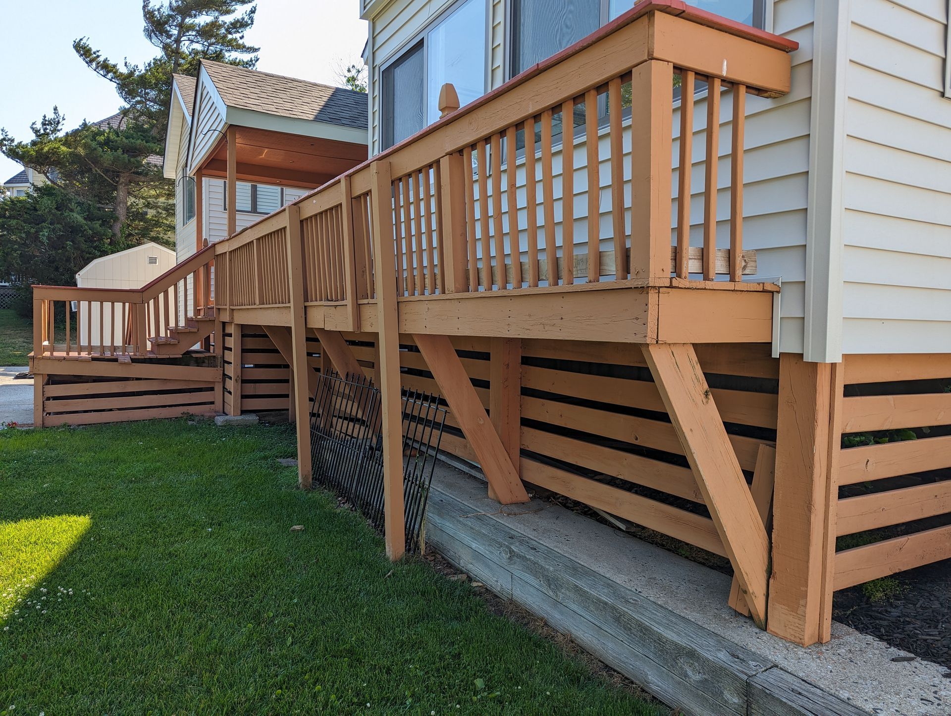 A wooden deck is attached to the side of a house.