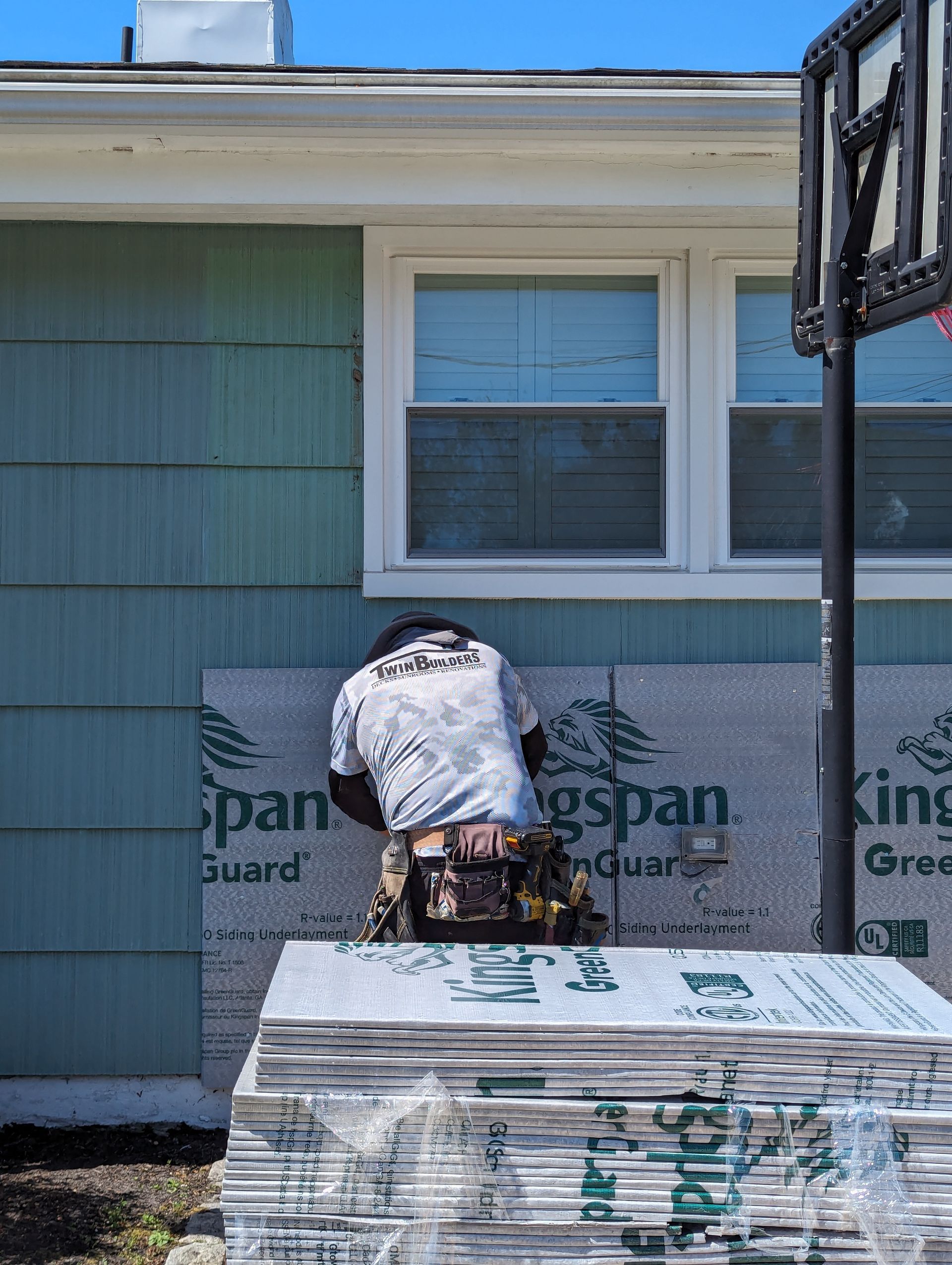 A man is working on the side of a house.