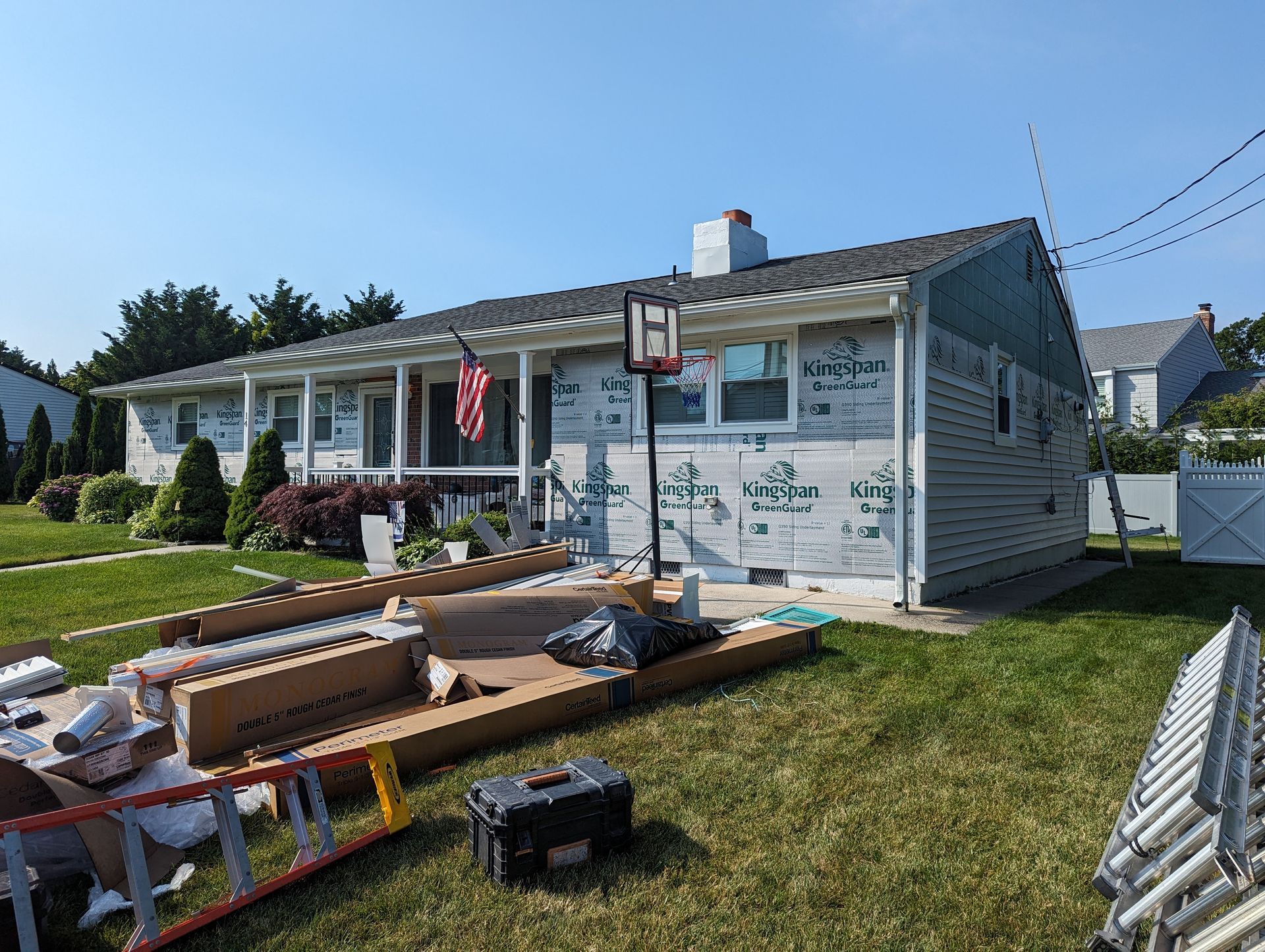 A house is being remodeled with a basketball hoop in the backyard.