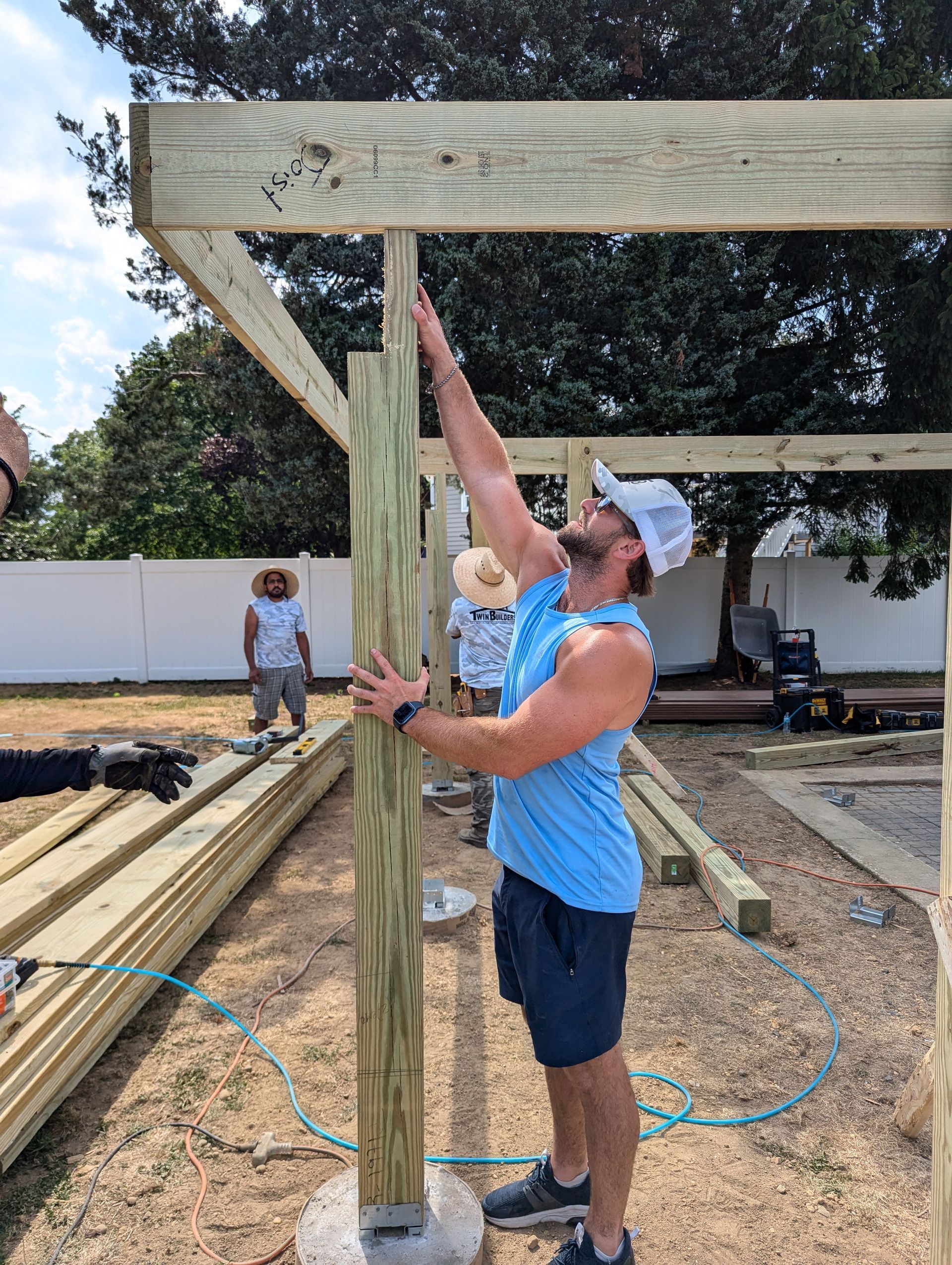 A man is standing next to a wooden post on a construction site.