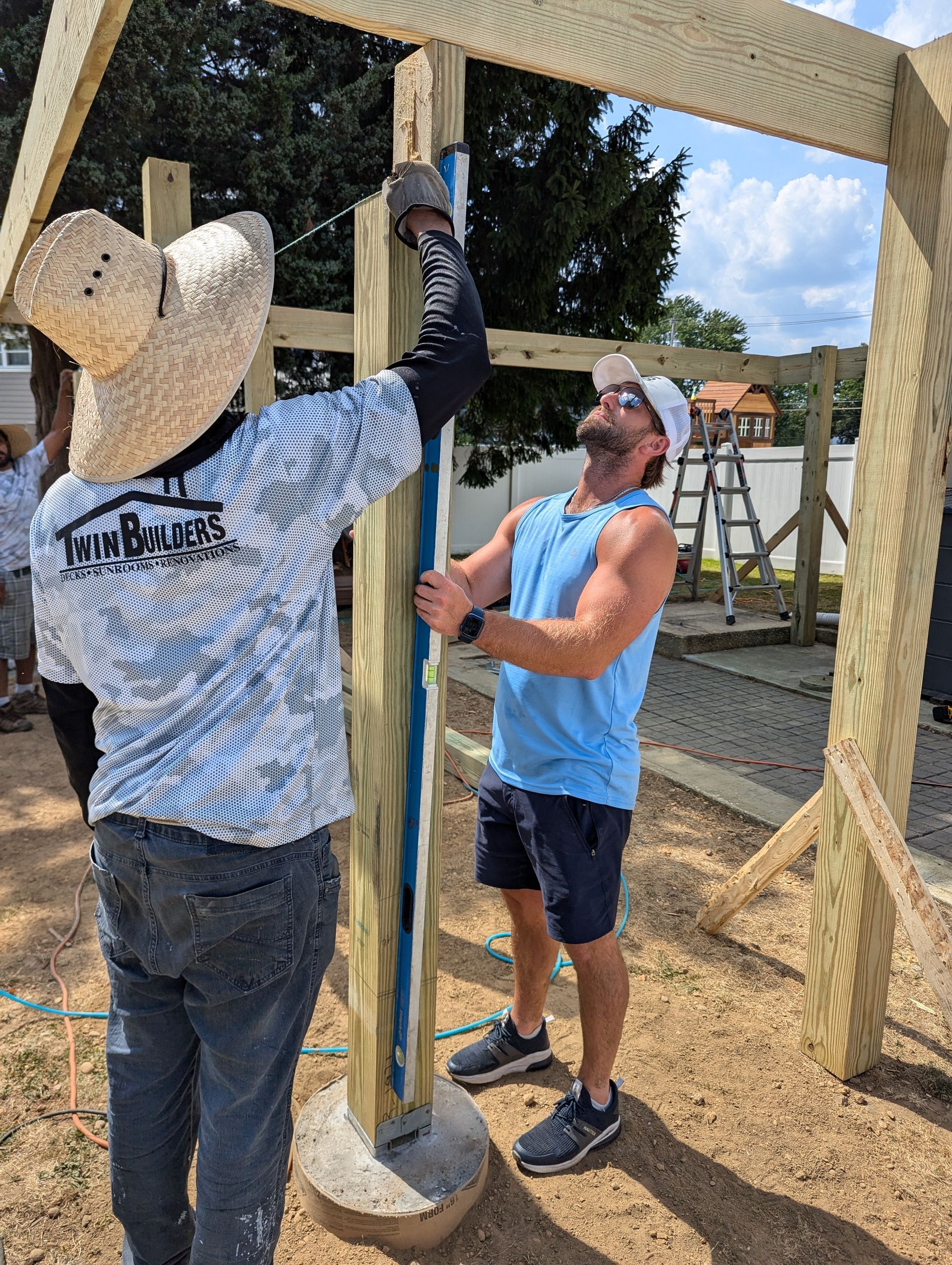 Two men are working on a wooden structure.