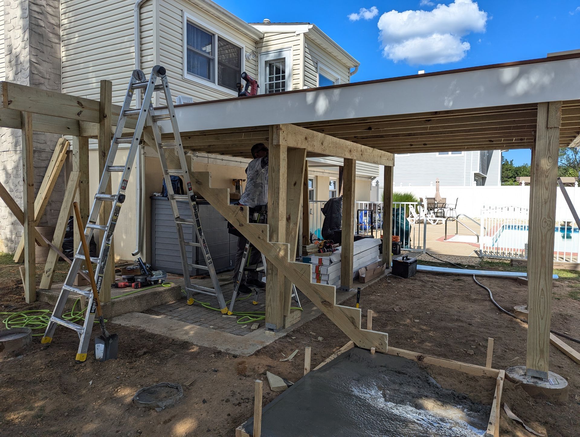 A wooden deck is being built in front of a house.