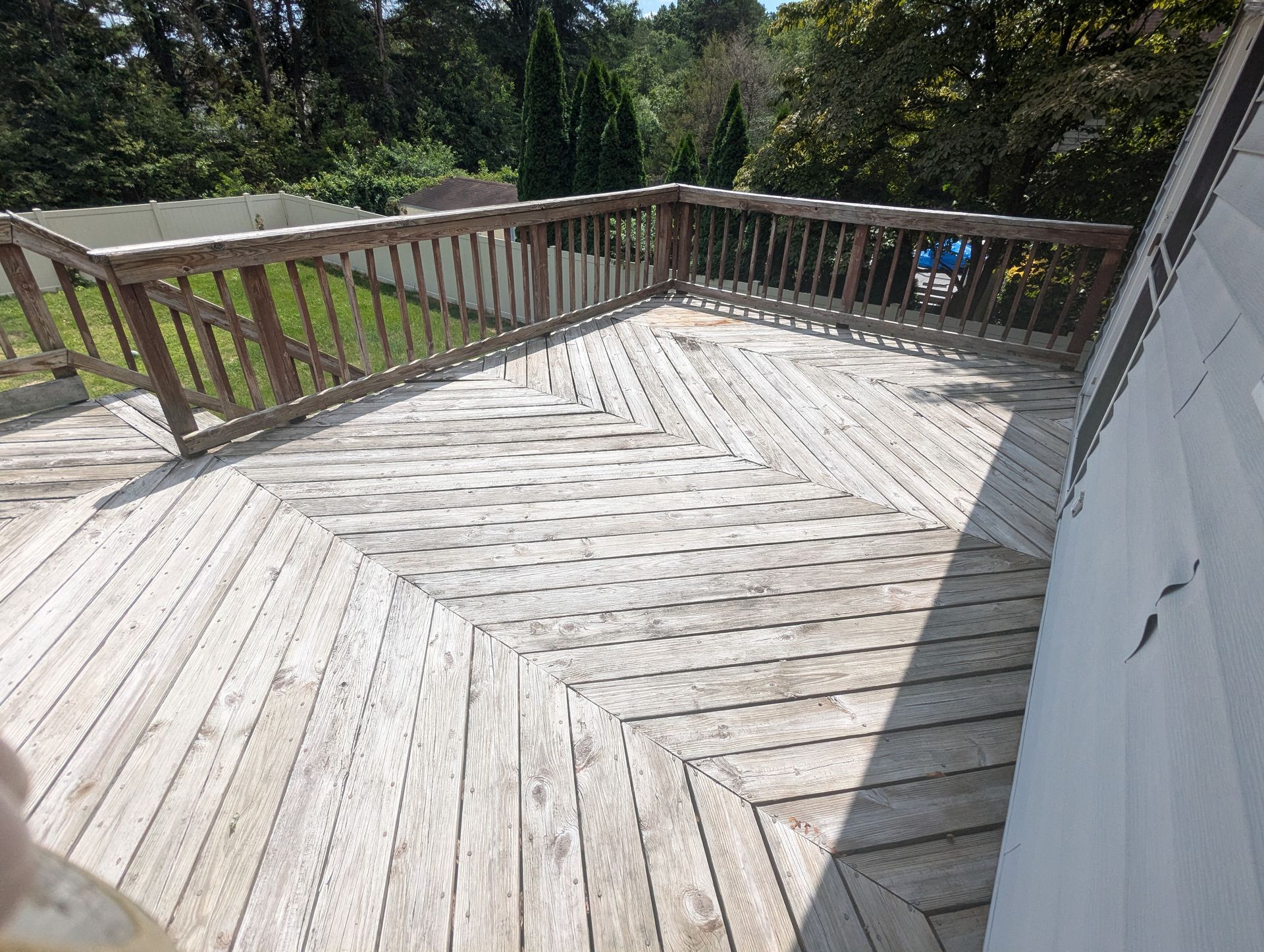 A wooden deck with a railing and a white door.