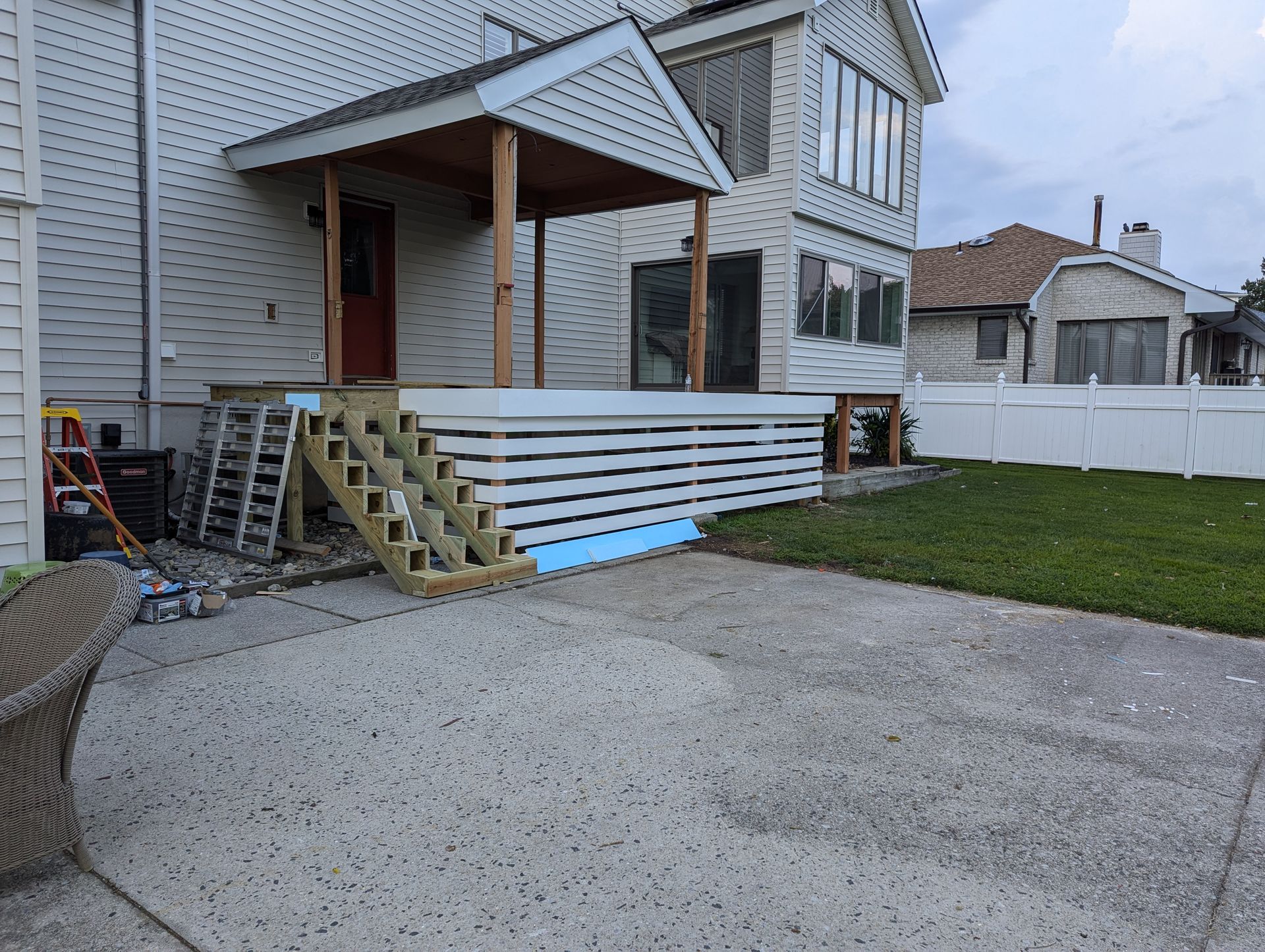 A house with a porch and stairs in front of it.