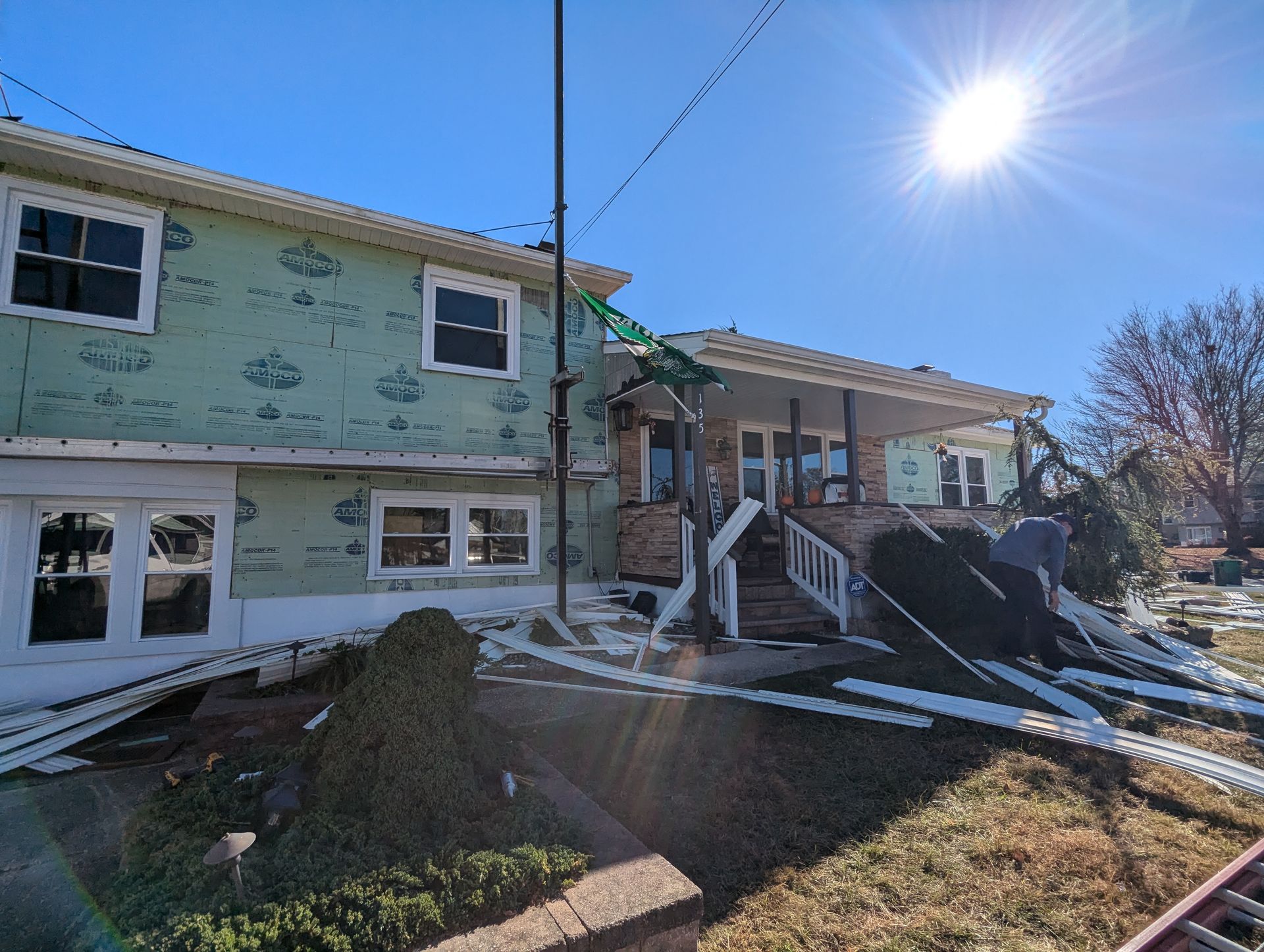 A house is being remodeled with a crane in the backyard.