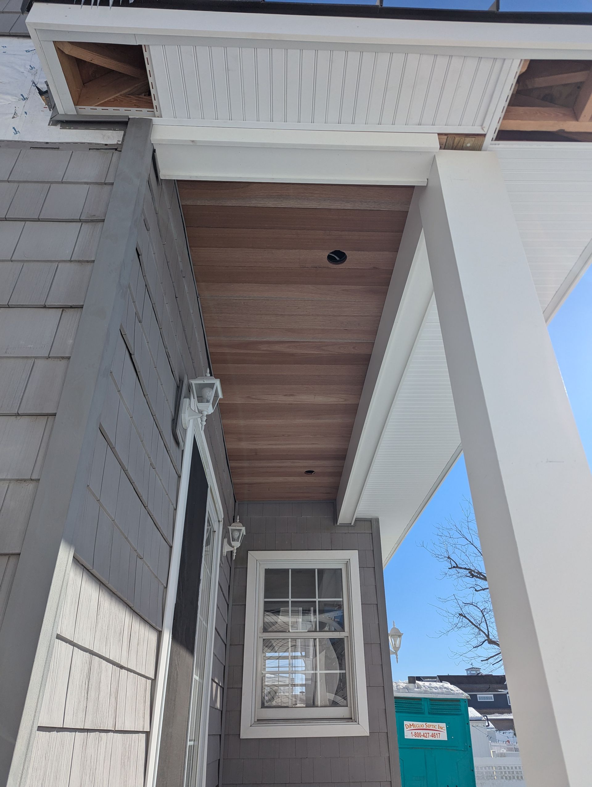 A house with a porch and a window underneath it.