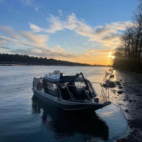 A boat is docked in the water at sunset.