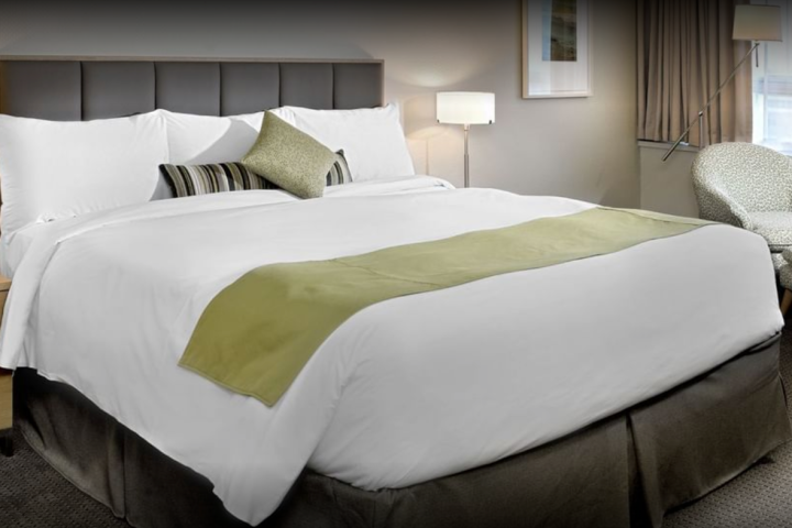 A hotel room with a large bed and a chair