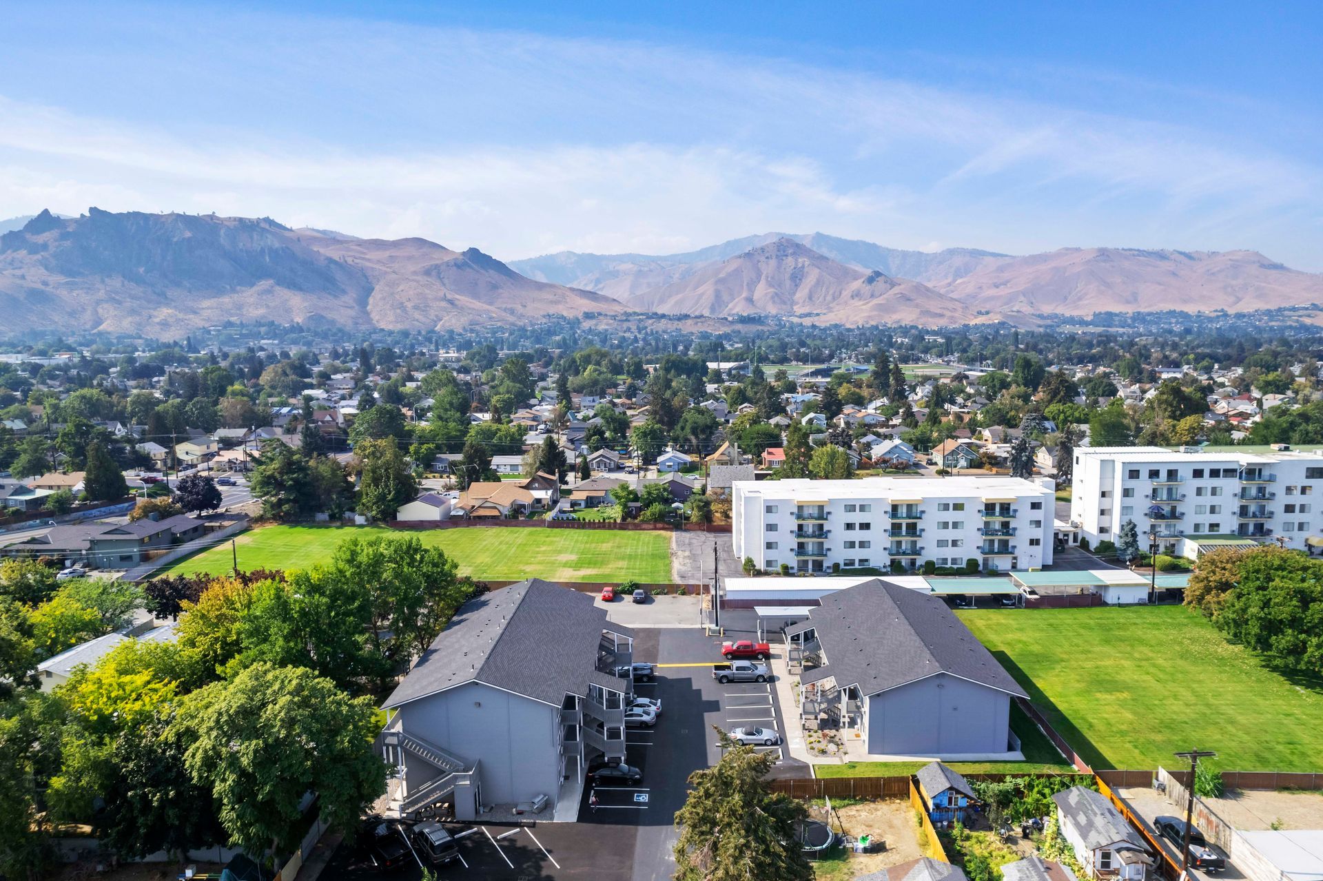 An aerial view of a residential area with mountains in the background.