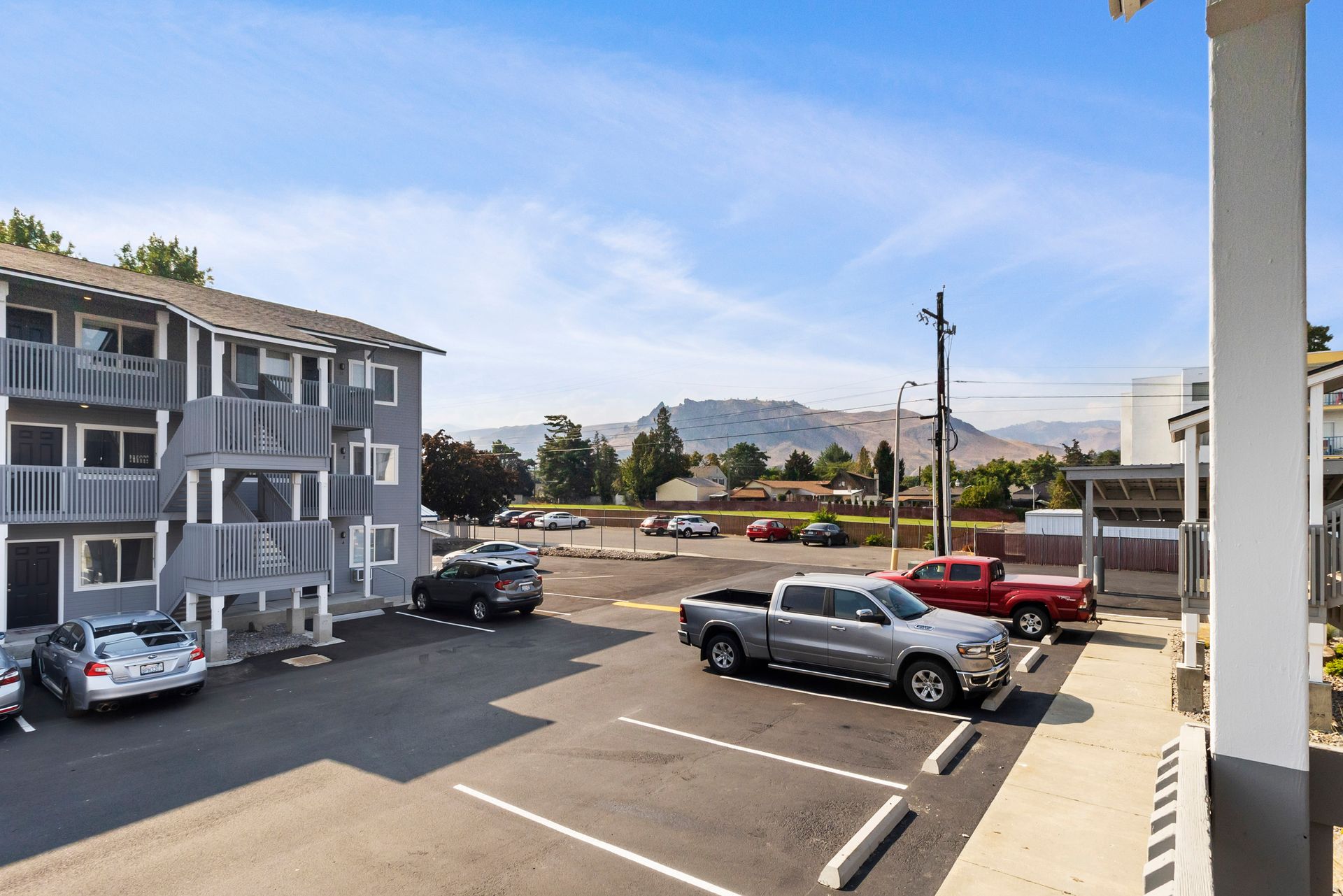 A parking lot with cars parked in front of a building.