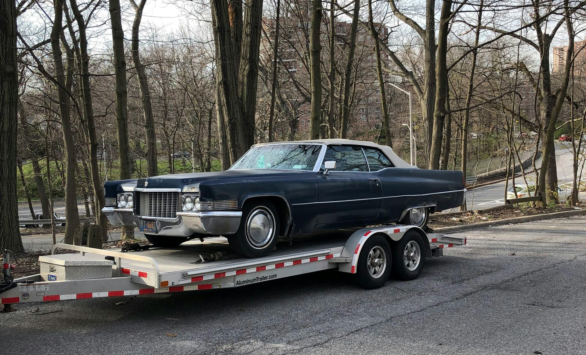 Old car on the back of a tow truck.