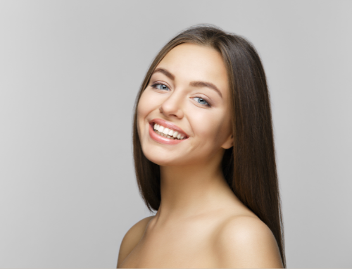 Woman With Long Brown Hair Smiles, Looking at the Camera — Aqua Marine Skin and Beauty in Tuncurry, NSW