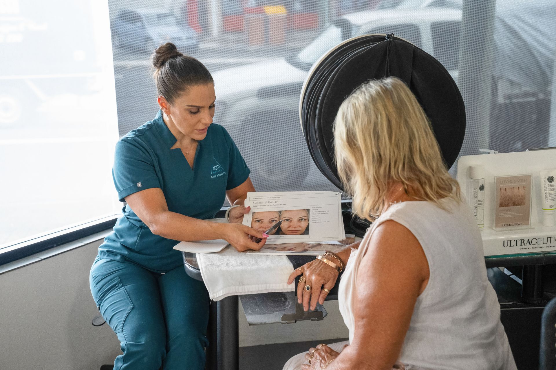 A Medical Professional Shows a Patient Before/after Photos of a Skin Treatment — Aqua Marine Skin and Beauty in Tuncurry, NSW
