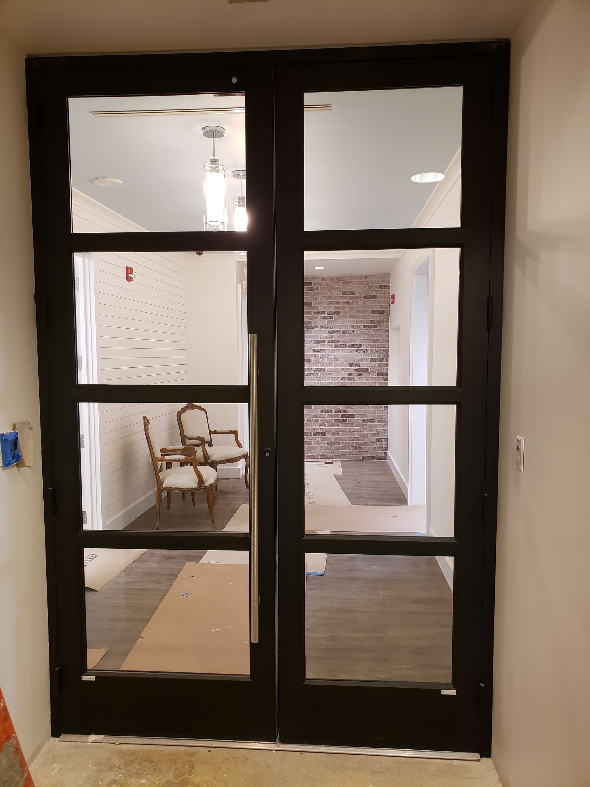 A dining room with a table and chairs behind a glass door.