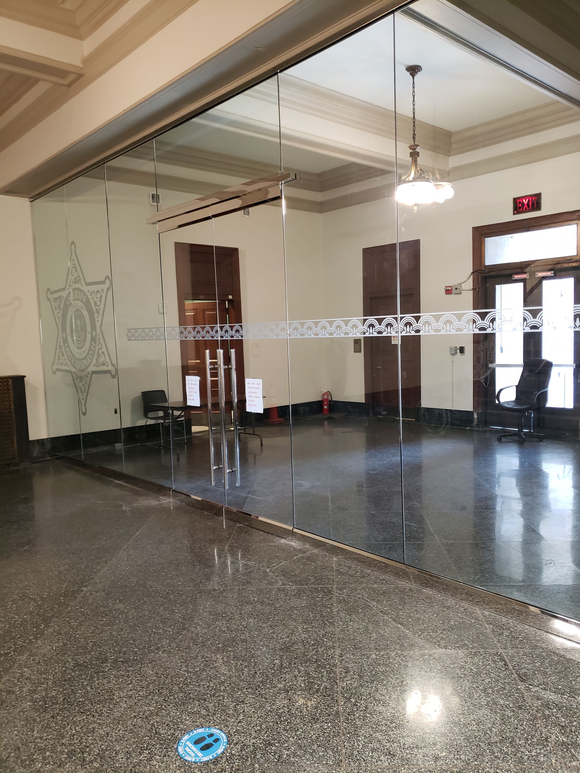A large room with a glass door and a ceiling fan