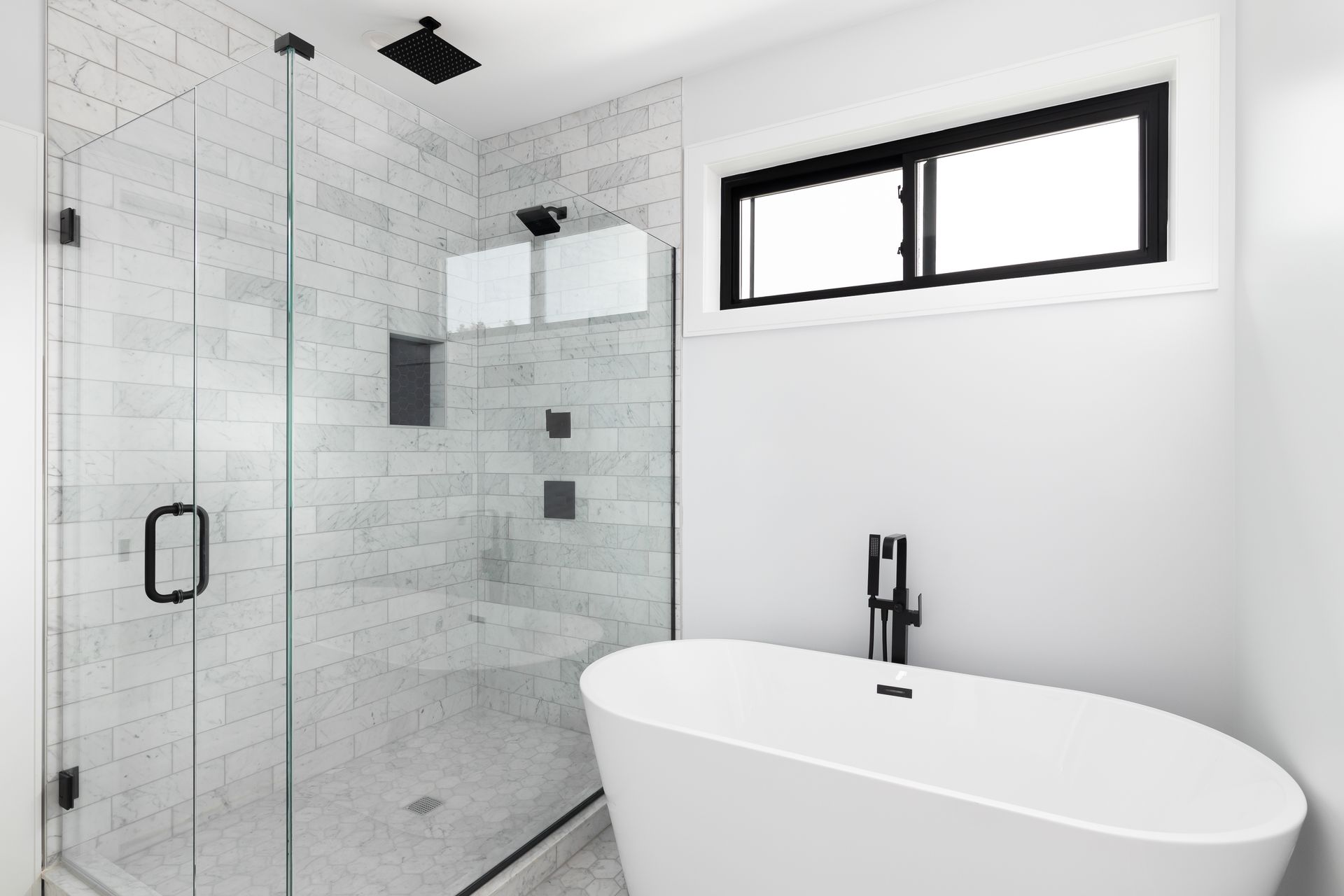 Modern bathroom with a glass shower enclosure beside a freestanding white tub.