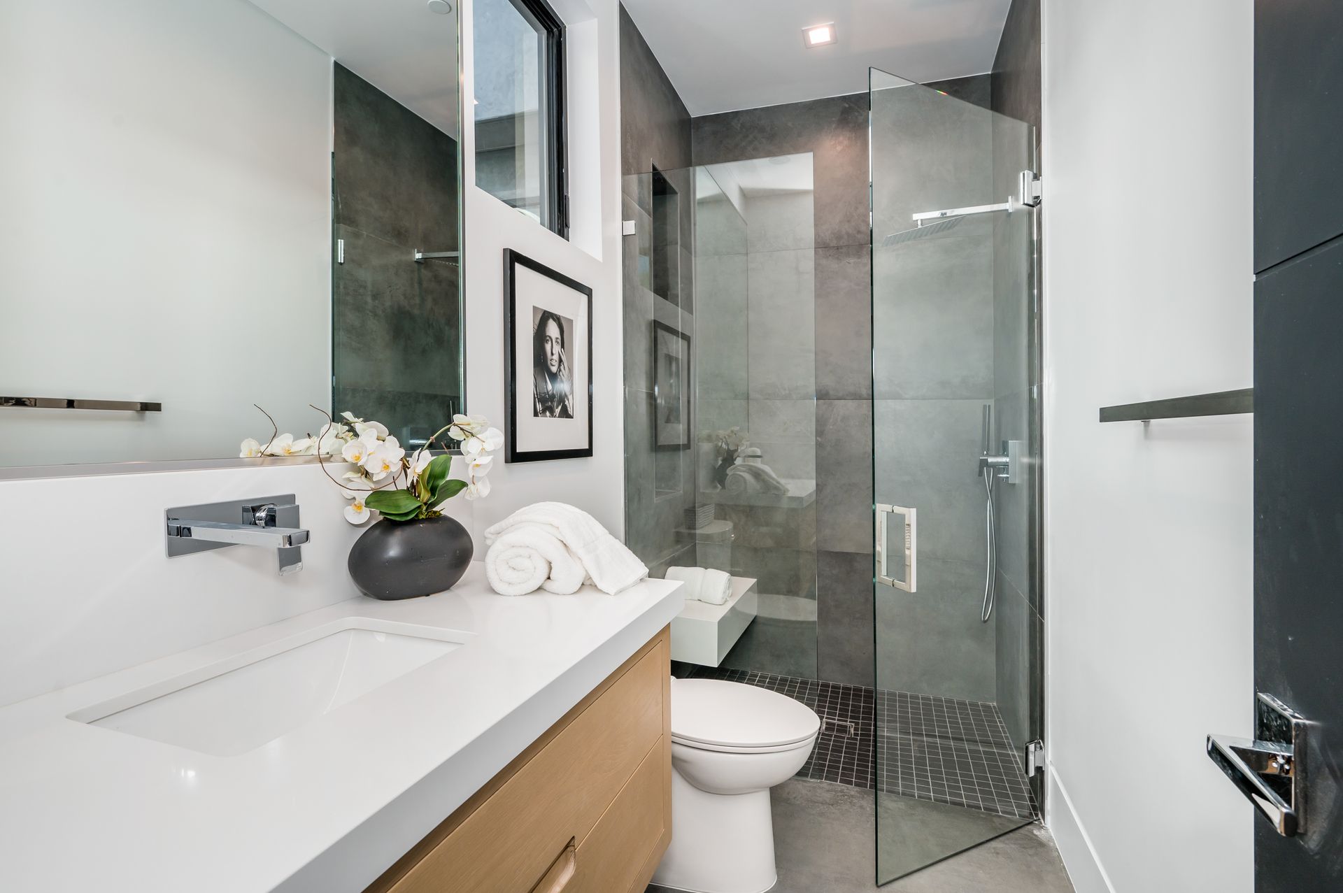 Stylish bathroom featuring a glass shower enclosure beside a modern vanity and toilet. Stylish bathroom featuring a glass shower enclosure beside a modern vanity and toilet.