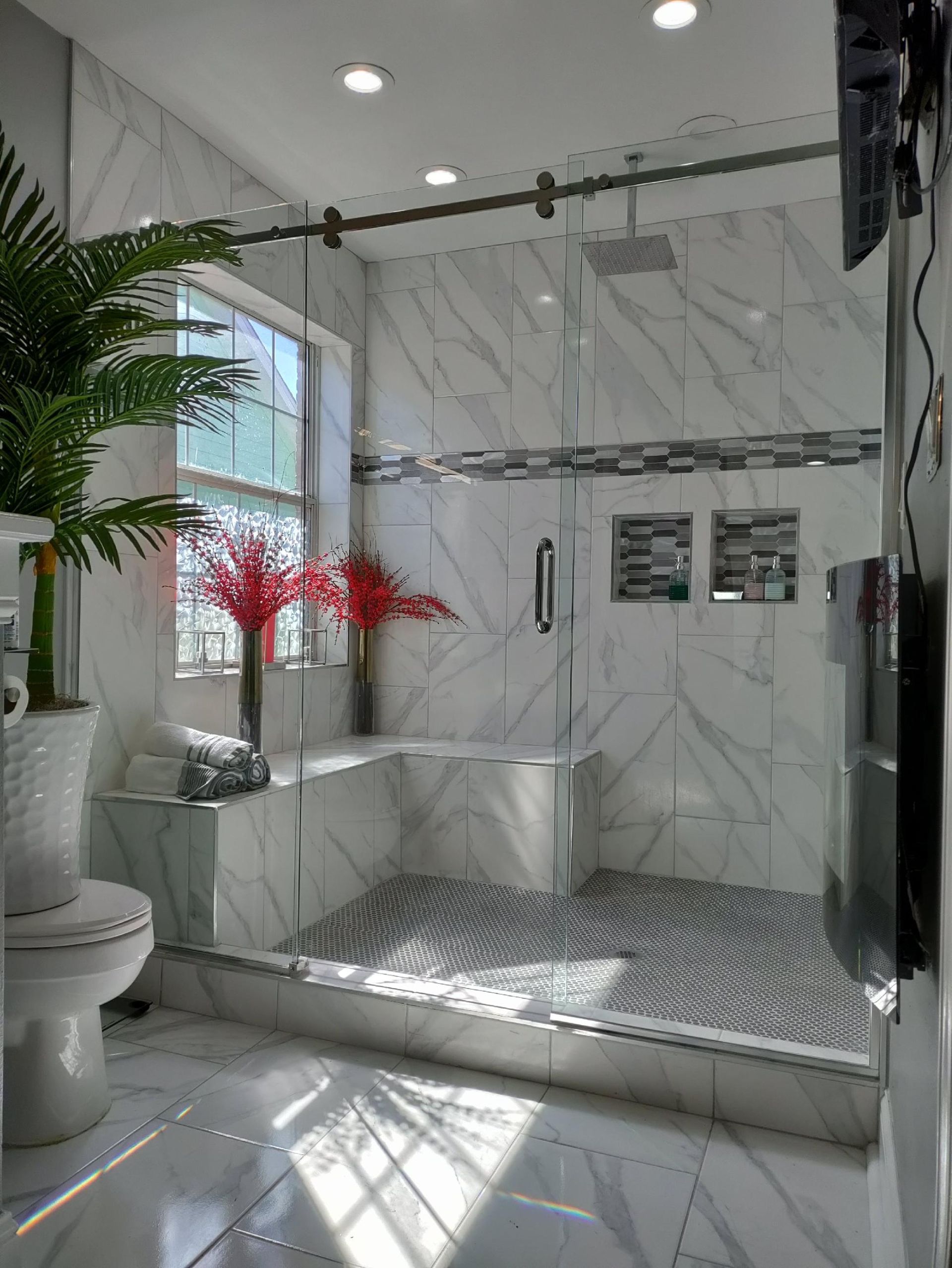 A bathroom with a walk in shower and a toilet.