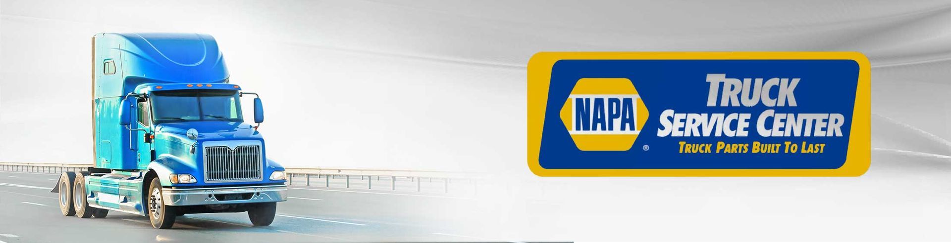 A blue truck is driving down a road next to a napa service center logo