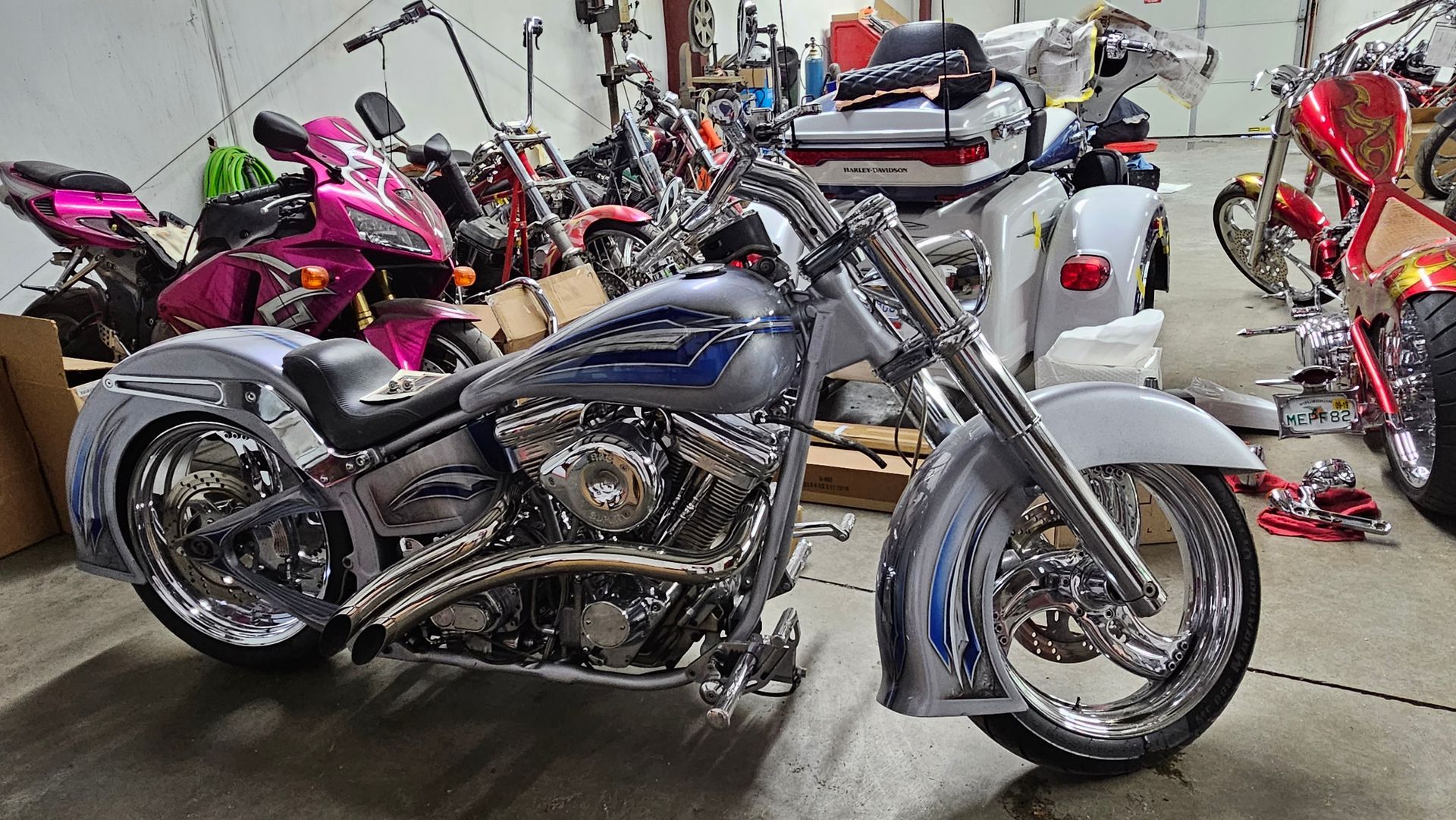 A motorcycle is parked in a garage surrounded by other motorcycles.