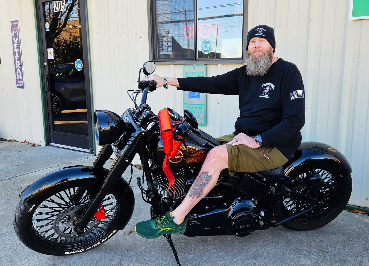 A man with a beard is sitting on a black motorcycle