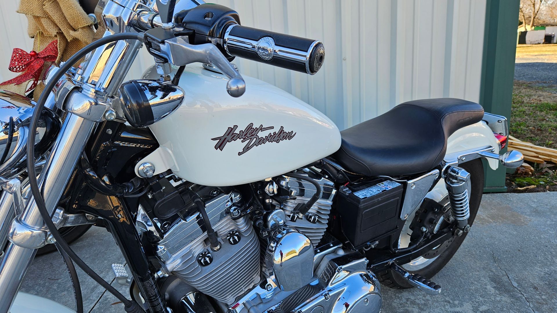 A white harley davidson motorcycle is parked in front of a building.