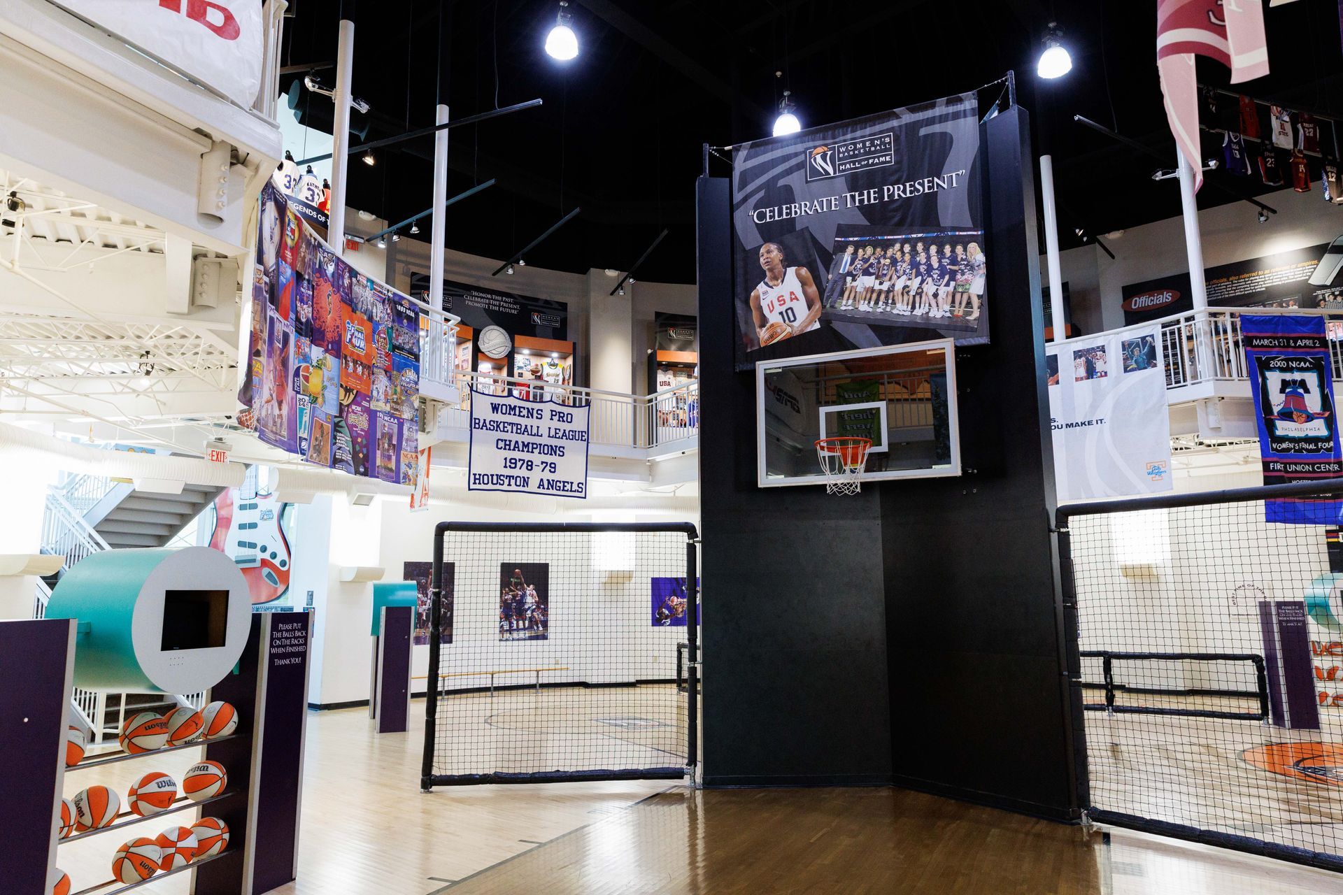 Indoor basketball arcade with a black hoop, posters, and bright lights in a game room