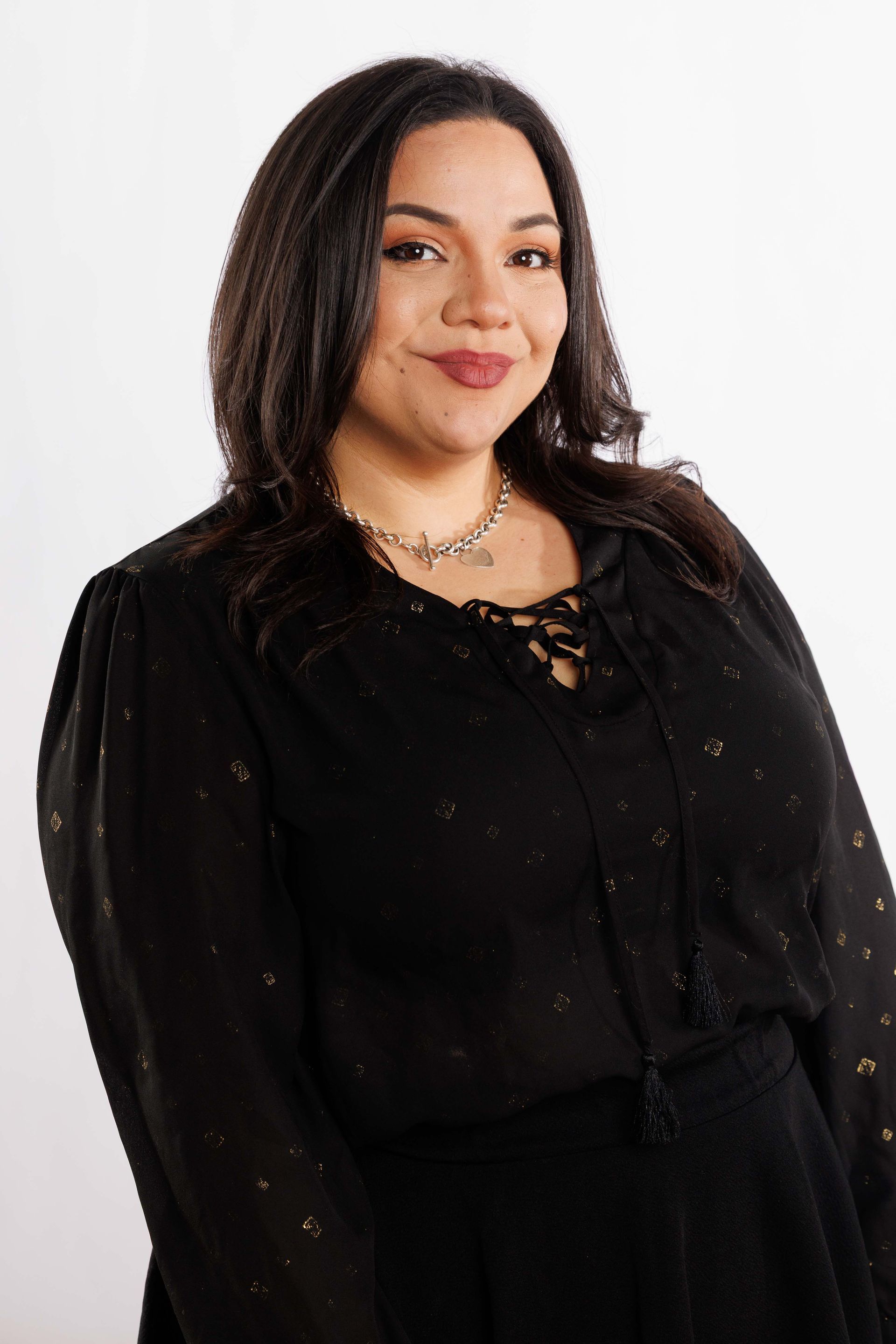 Portrait of a smiling person in a black outfit against a white background