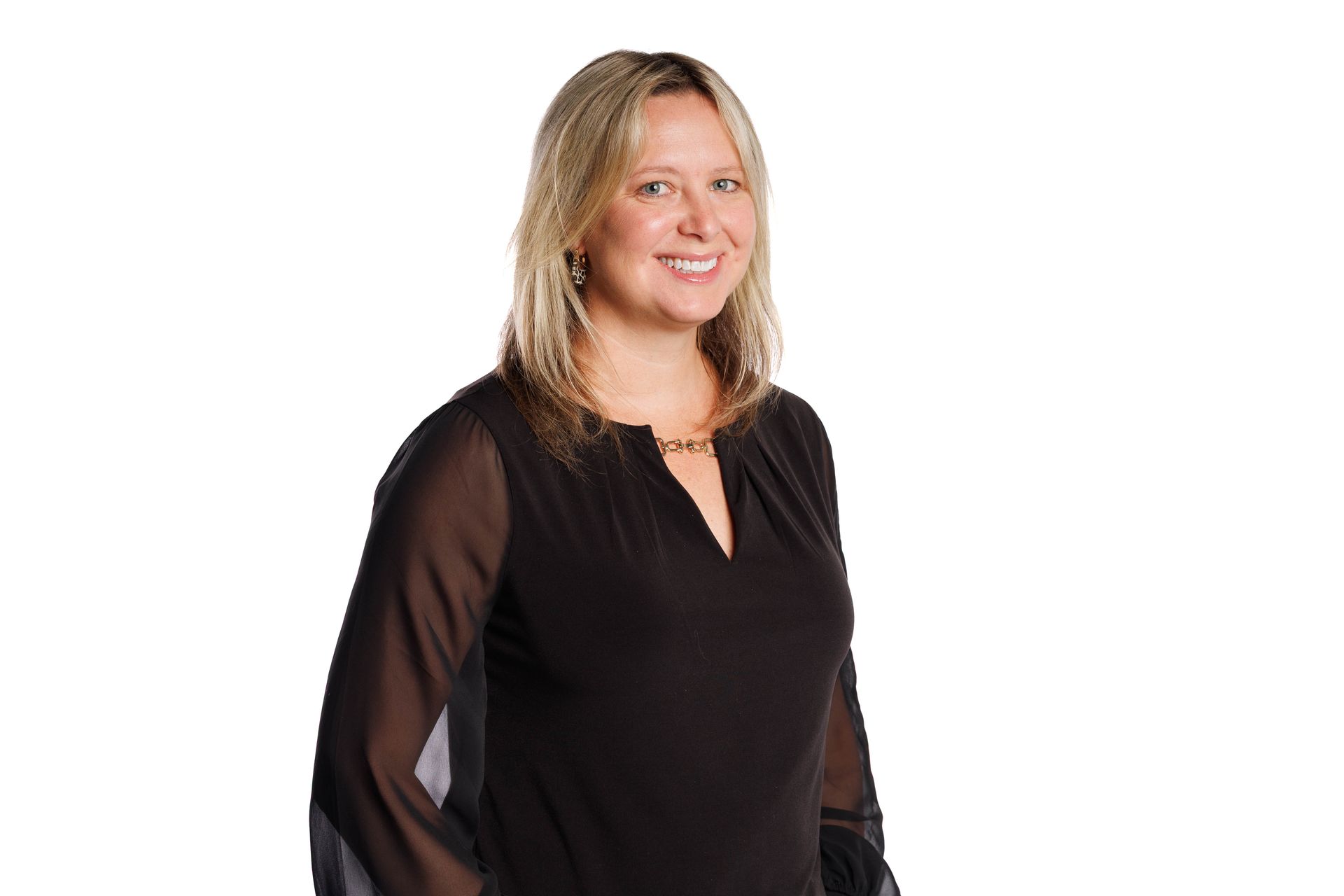 Smiling woman in a patterned blazer over a black top against a white background