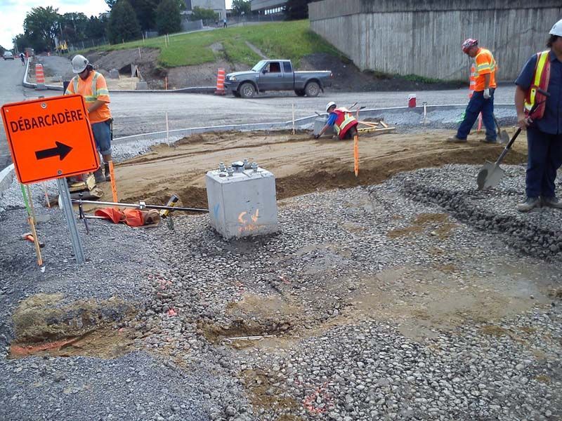 Un groupe de travailleurs de la construction travaillent sur une route