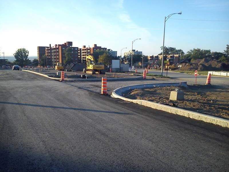 Un chantier de construction avec une pelle jaune et des cônes orange