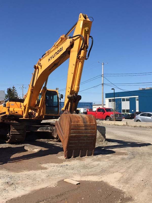 Une pelle Hyundai jaune est garée sur le bord de la route