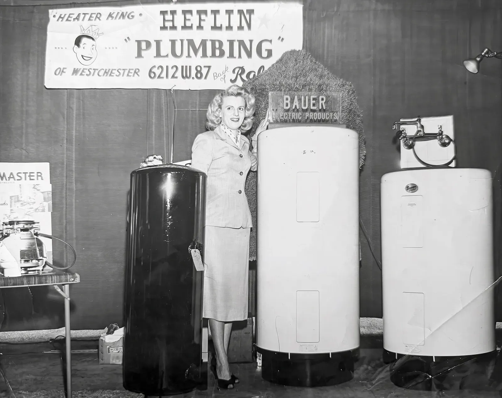 Historic photo of Heflin Plumbing displaying water heaters and plumbing equipment in the original showroom.